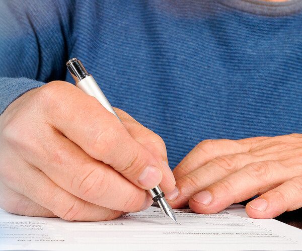 Mann füllt ein Dokument aus