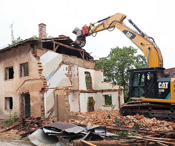 Bagger reißt altes Haus ab