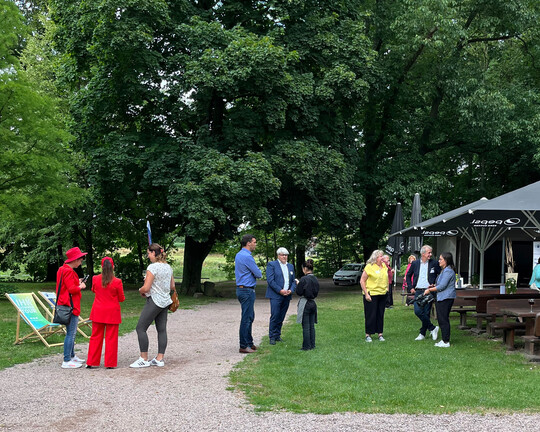 Impressionen der IHK-Sommertour 2025 in Podelwitz: Menschen stehen neben einer Terrasse und reden