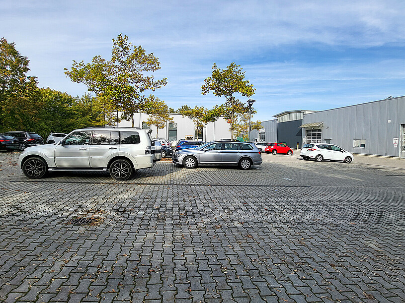 Parkplatz mit Fahrzeugen und Bäumen