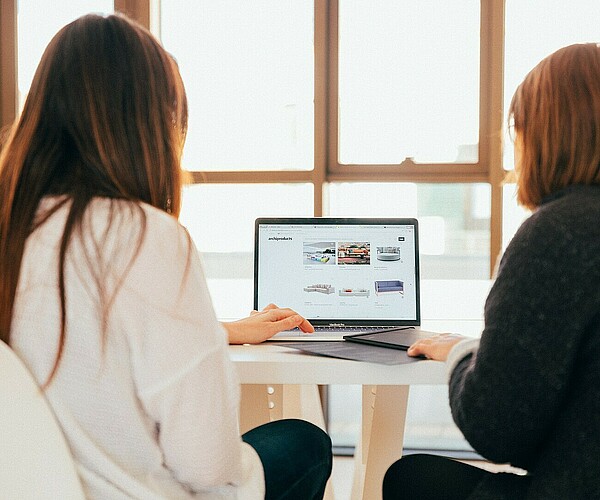 Zwei Frauen arbeiten an einem Laptop