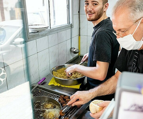 zwei Küchenarbeiter kochen Essen