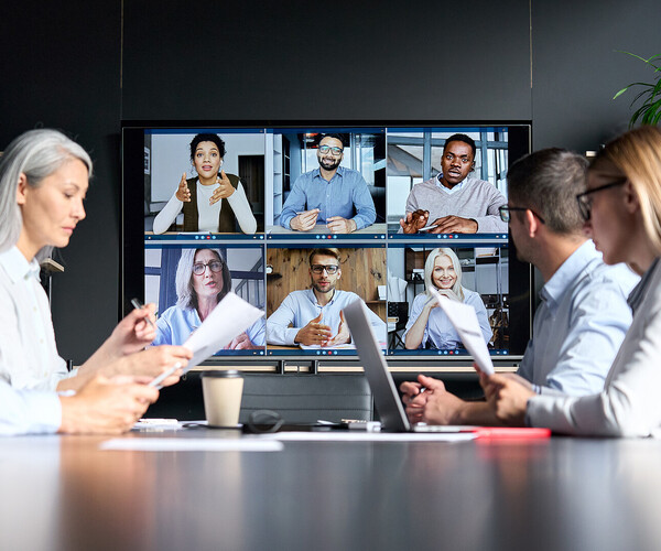 Global corporate video call in meeting room with diverse multiethnic people.