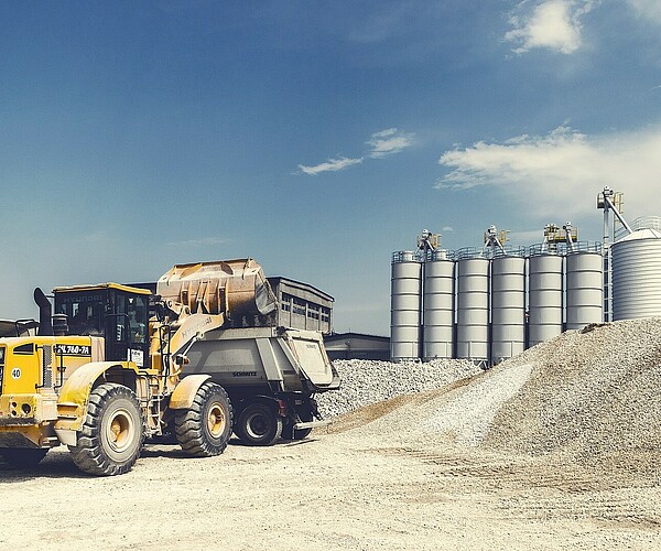 Bagger schippt Sand in einen Laster