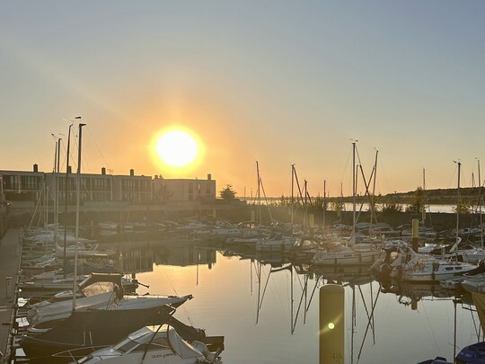 IHK-Sommertour 2025: Hafen Zwenkau mit Booten, im Hintergrund geht die Sonne unter.