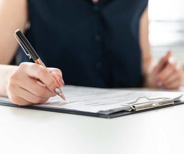 Women's hands fill out a questionnaire.