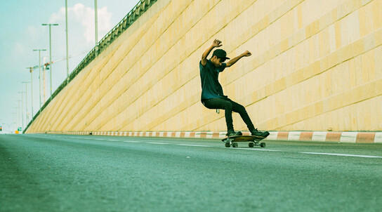 Skater fährt an einer Mauer entlang