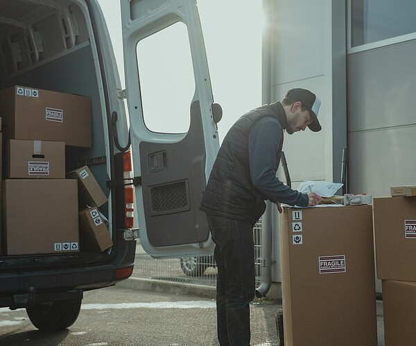 Pakete werden von einem Mann in ein Auto gebracht