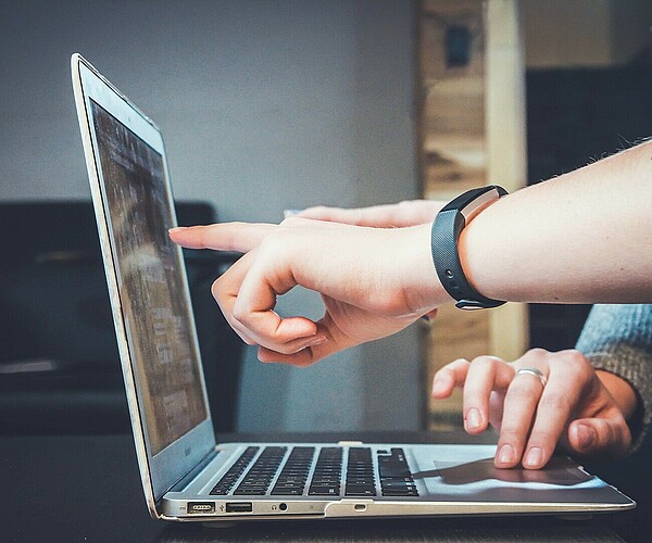 Zwei junge Menschen arbeiten an einem Laptop