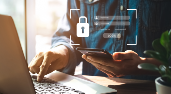 Person arbeitet an PC und Handy und zeigt Datenschutz auf