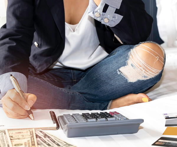 Frau zählt Geld mit Taschenrechner