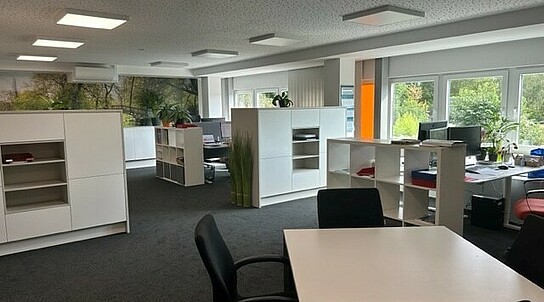 Büroraum mit Tischen, Stühlen, Raumteilern, Regalen