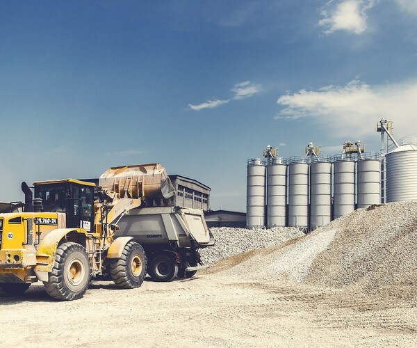 Bagger schippt Sand in einen Laster
