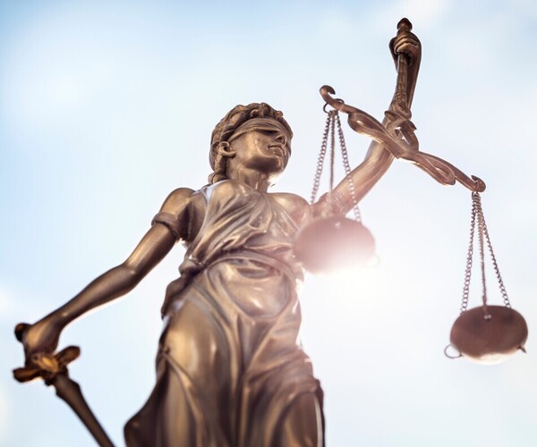 Justitia vor der Sonne mit Schwert und Waage 