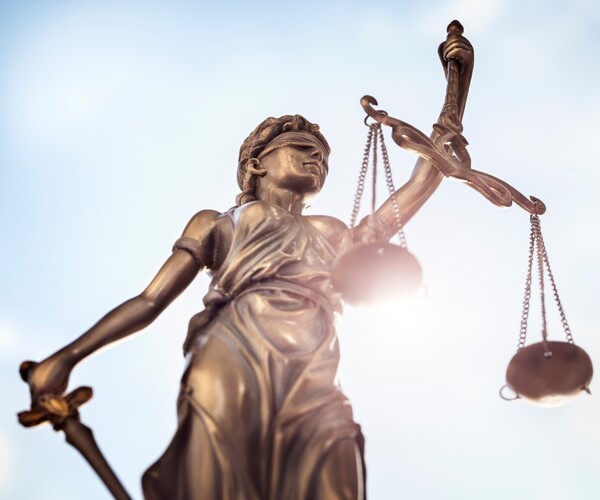 Justitia vor der Sonne mit Schwert und Waage 