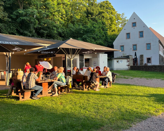 Impressionen der IHK-Sommertour 2025 in Podelwitz: Menschen sitzen auf der Terrasse