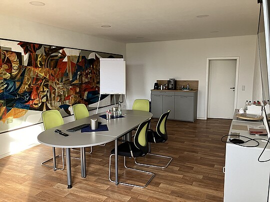 Konferenzraum mit Tisch, Stühlen, Schränken