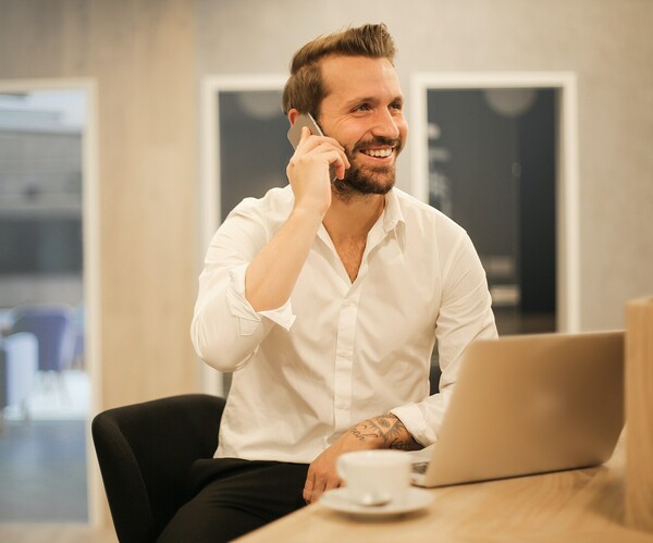 junger Mann telefoniert mit einem Lächeln