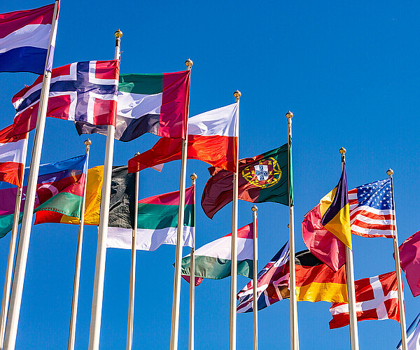 Flags of different countries flutters in the wind against