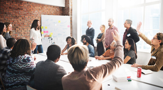 Menschen, die an einem Tisch sitzen und an einem Workshop teilnehmen