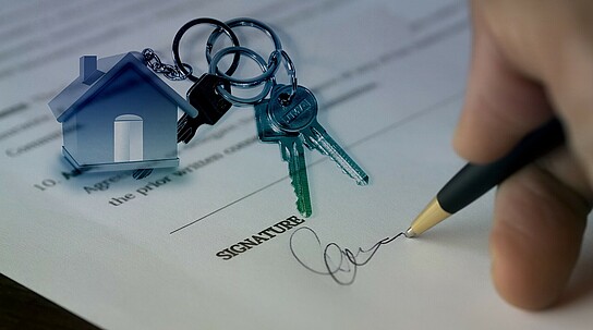 Person unterschreibt Immobilienvertrag