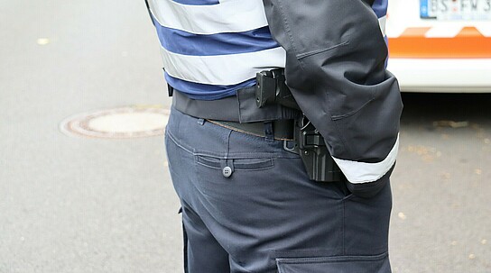 Polizist oder Bewacher trägt Waffengürtel mit Pistole 
