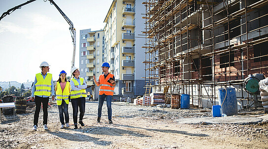 Bauarbeiter unterhalten sich neben Baustelle