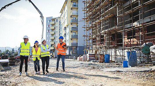 Bauarbeiter unterhalten sich neben Baustelle