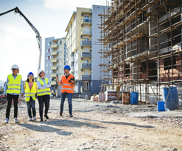 Bauarbeiter unterhalten sich neben Baustelle