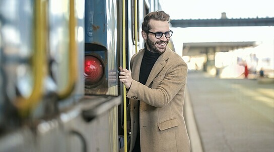 Mann steigt in Zug ein