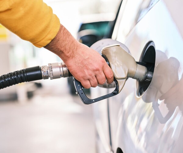 Ein Auto wird mittels Tankpistole mit Benzin vollgetankt