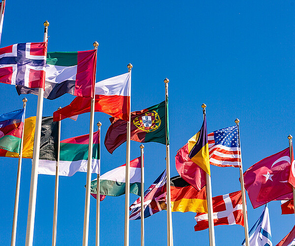 Flags of different countries flutters in the wind against