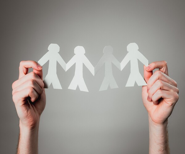 Hände halten Papiermenschen hoch