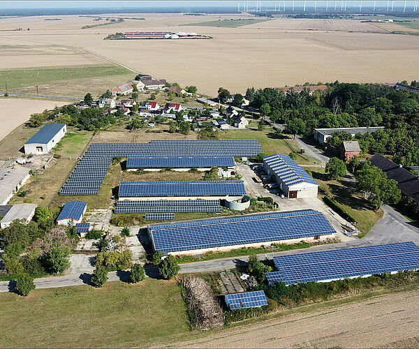 Luftbild mit Hallen und Fotovoltaikanlagen