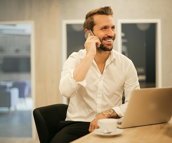 junger Mann telefoniert mit einem Lächeln