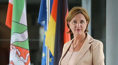 Portrait Ministerin Fahnen