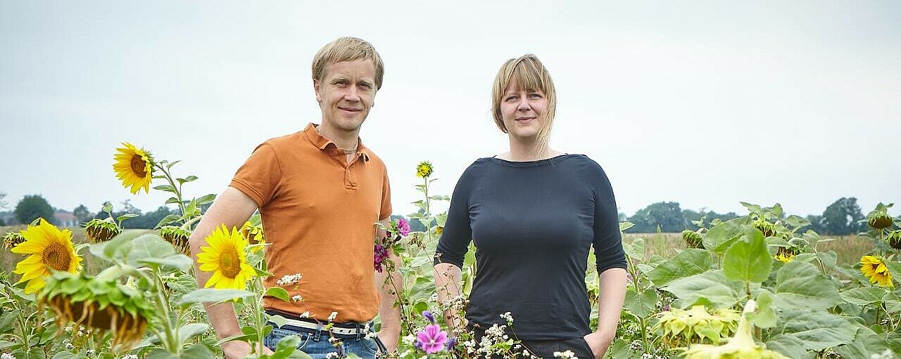 Robert Künne und Johanna Tschiersch von der Lerchenbergmühle stehen im Feld zwischen Sonnenblumen